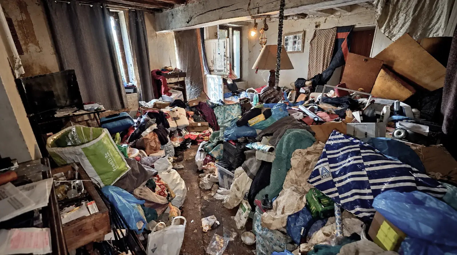 Pièce de vie totalement encombrée avant le débarras sanitaire d’une maison à Blois